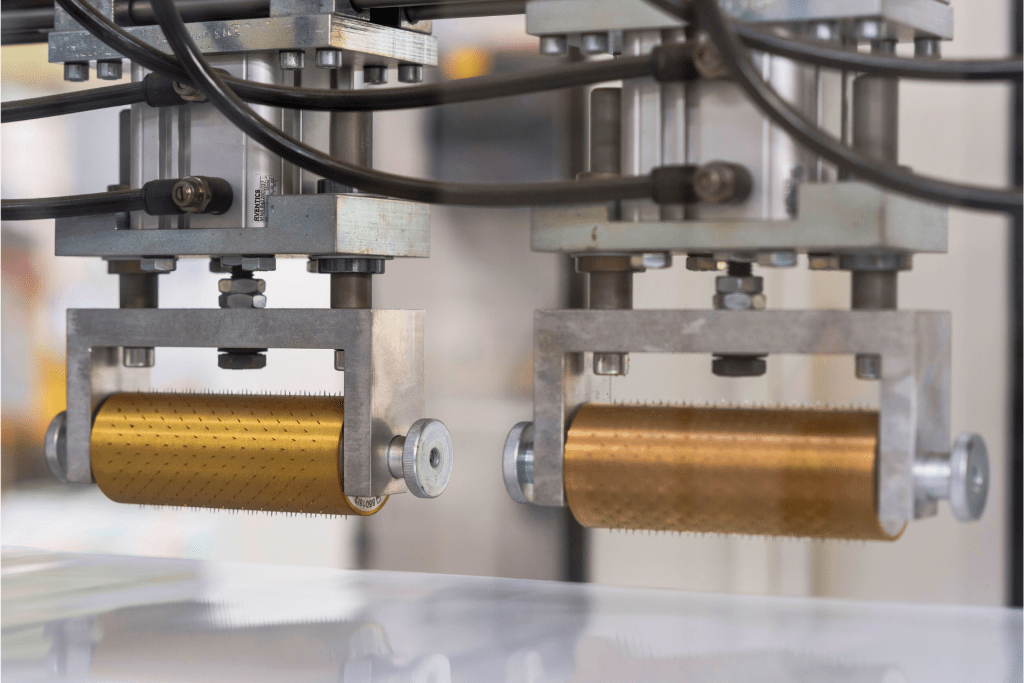 Manufacturing packaging machine applying foil to industrial sack material in a fast, high-speed process.