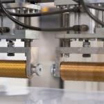 Manufacturing packaging machine applying foil to industrial sack material in a fast, high-speed process.