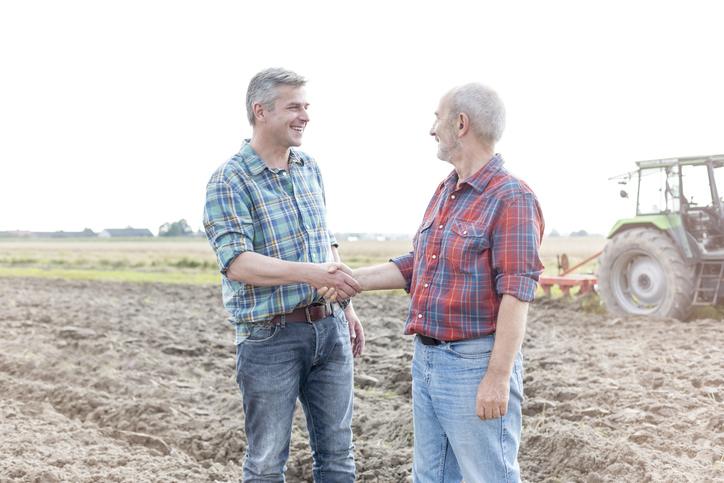 Territory manager idaho and utah chatting and shaking hands with farmer.